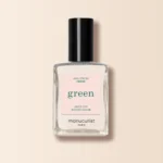 „Manucurist Green Creme“ nagų lakas labai šviesaus atspalvio, pastatytas ant šviesaus fono.