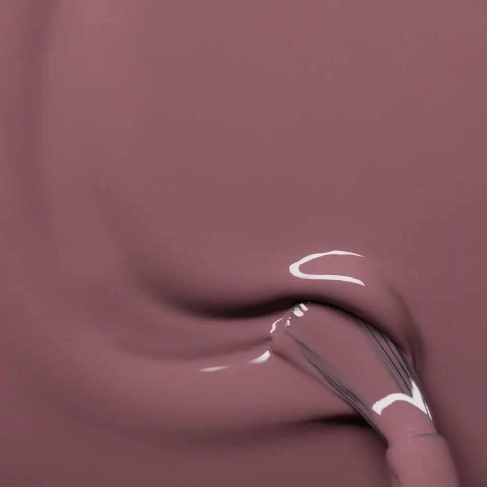 Violetinis nagų lakas tepamas ant paviršiaus stambiu planu.