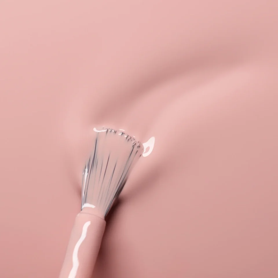 Šviesiai rožinis nagų lakas tepamas ant paviršiaus su „Manucurist“ teptuku iš arti, tekstūra